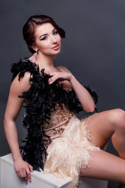 Portrait of happy brunette beautiful woman in boa from ostrich feathers . 20's years. Verycal photo - Фото, изображение