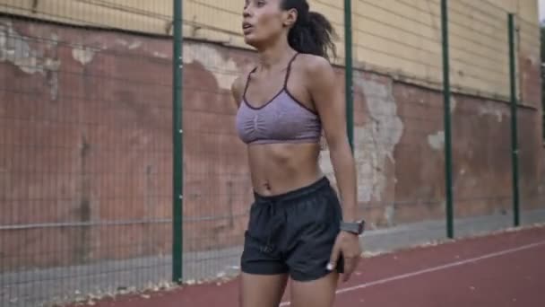 A serious african american woman in sportswear is running outdoors at the stadium - 映像、動画