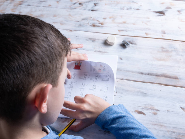 7 year old boy doing his homework, isolated, education concept - Photo, Image