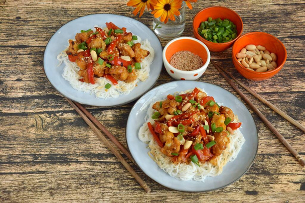 Květák Kung Pao s rýžovými nudlemi. Ozdobte arašídy, hřebenatkami a sezamovými semínky. Veganské jídlo - Fotografie, Obrázek