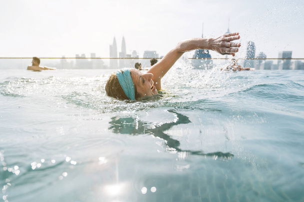 Donna che nuota nella piscina a sfioro
 - Foto, immagini