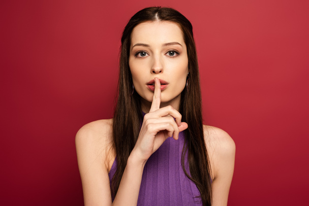 portrait of beautiful woman showing silence symbol on red - Photo, image