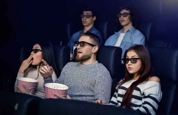 Recreation and leisure. Emotional friends watching 3D film in cinema - Photo, image