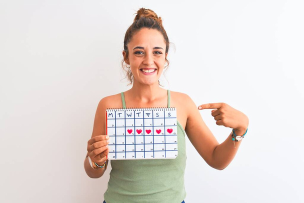 若いですredhead女性保持月経カレンダー上の隔離された背景非常に幸せなポインティングとともに手と指 - 写真・画像