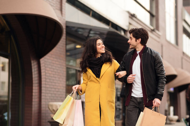 Loving couple walking carrying shopping paper bags - Photo, Image
