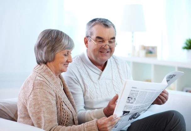 Зрелая пара читает газету вместе
 - Фото, изображение