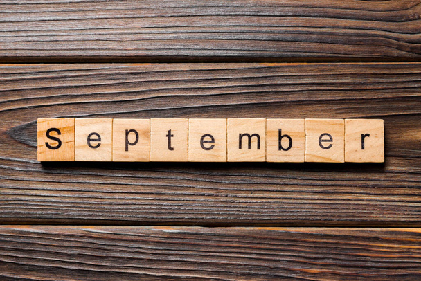 September woord geschreven op hout blok. September tekst op houten tafel voor uw desing, Top view concept. - Foto, afbeelding