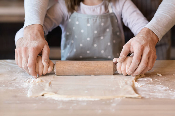Onherkenbare man en kleine dochter Rolling Pastry Dough samen, Close-up - Foto, afbeelding