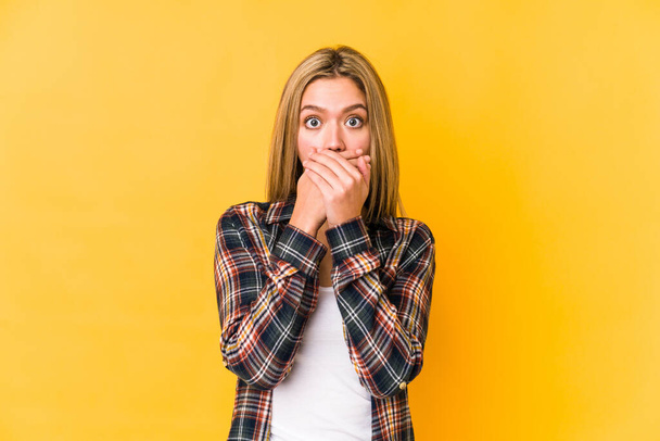 Young blonde caucasian woman isolated on yellow background shocked covering mouth with hands. - Photo, Image