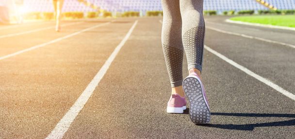 Oříznout obrázek ženských sportovních nohou a chodidel v běžecké obuvi na stadionu. - Fotografie, Obrázek