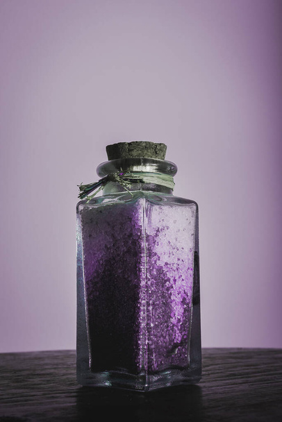 luxe fles met lavendel badzout voor ontspannende spa-behandelingen met witte achtergrond - Foto, afbeelding