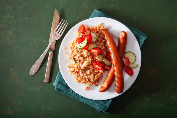 régime paléo cétogène déjeuner. riz au chou-fleur et saucisses grillées - Photo, image