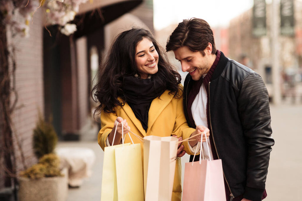 Young loving couple looking inside shopping bags - Photo, Image