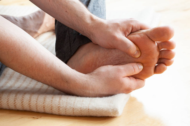 hombre haciendo flatfoot corrección auto masaje en casa - Foto, Imagen