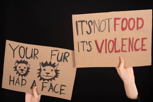 partial view of woman holding cardboard signs with your fur had a face and its not food its violence inscriptions isolated on black - Photo, Image