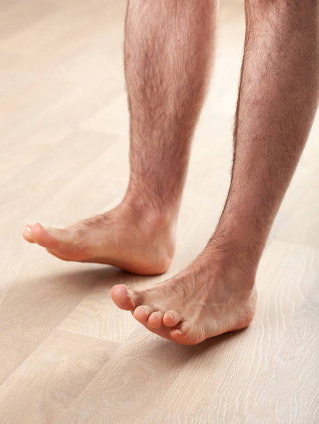uomo fare flatfoot correzione ginnastica esercizio toe solleva a casa
 - Foto, immagini