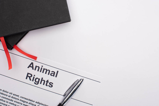 vue en haut de l'inscription sur les droits des animaux, cahiers noirs et stylo sur fond blanc
 - Photo, image