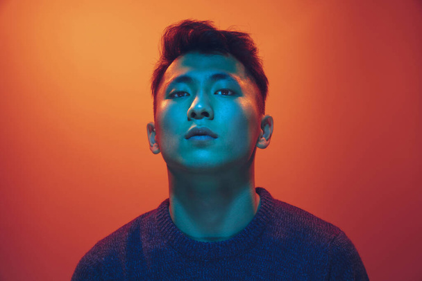 Portrait of a guy with colorful neon light on gradient background - cyberpunk concept - 写真・画像