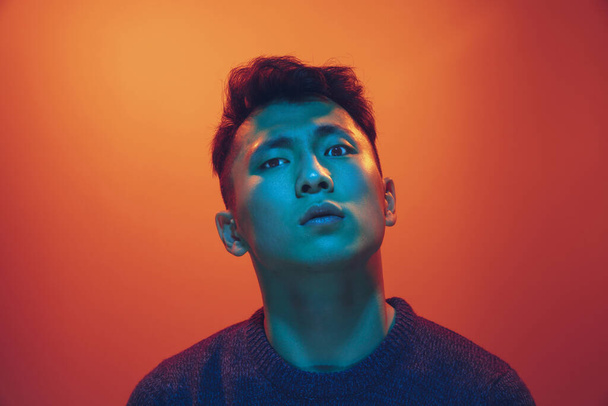 Portrait of a guy with colorful neon light on gradient background - cyberpunk concept - Fotó, kép