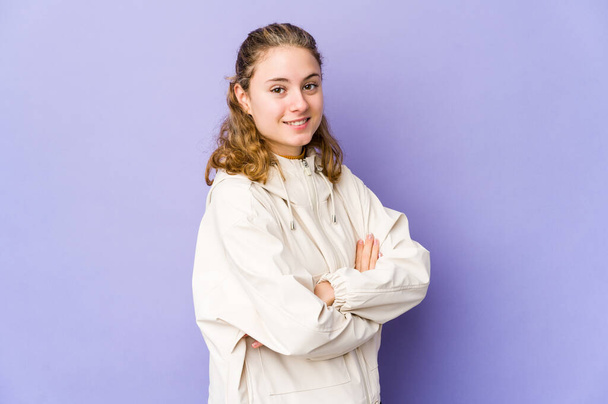 Young caucasian woman on purple background happy, smiling and cheerful. - Фото, зображення