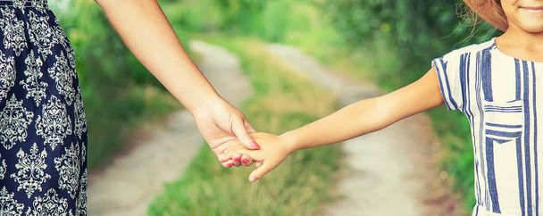 child goes hand in hand with his mother. Selective focus. nature. - Foto, afbeelding