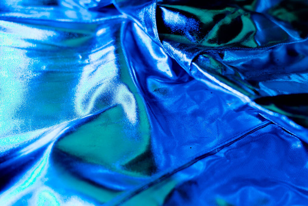 Bright blue holographic neon foil background. Multicolor trendy backdrop. Copyspace top horizontal view - Photo, Image