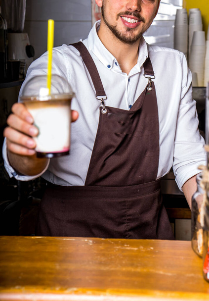 Бариста делает кофе на фоне кафе
 - Фото, изображение