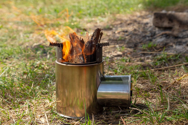 Equipements et outils touristiques : poêle de camping en feu. Brûlage sur un camping
. - Photo, image