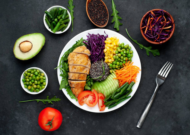 grilled chicken fillet with vegetables and herbs on a dark background, top view. Avocado, chia, corn and green beans - Photo, Image