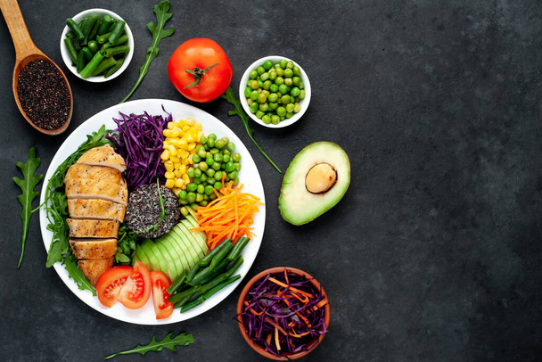 gegrilde kipfilet met groenten en kruiden op een donkere achtergrond, bovenaanzicht. Avocado, chia, maïs en sperziebonen - Foto, afbeelding