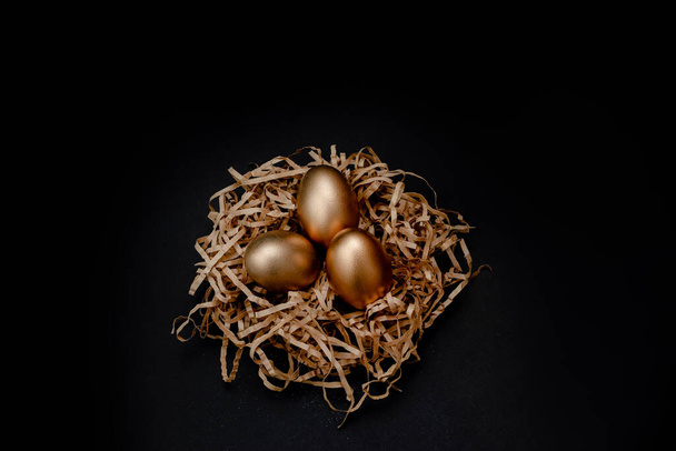 Пасхальні золоті прикрашені яйця в гнізді на білому тлі. Мінімальний простір копіювання Великодня для тексту. Верхній горизонтальний вигляд, плоский
. - Фото, зображення