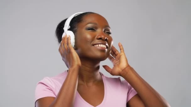 african woman in headphones listening to music - Felvétel, videó
