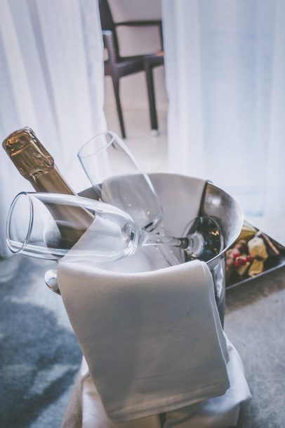 A bucket of champagne and fruit on the table - 写真・画像