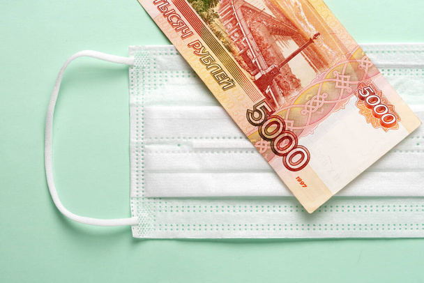 Medical mask with Russian money lying on it. - 写真・画像