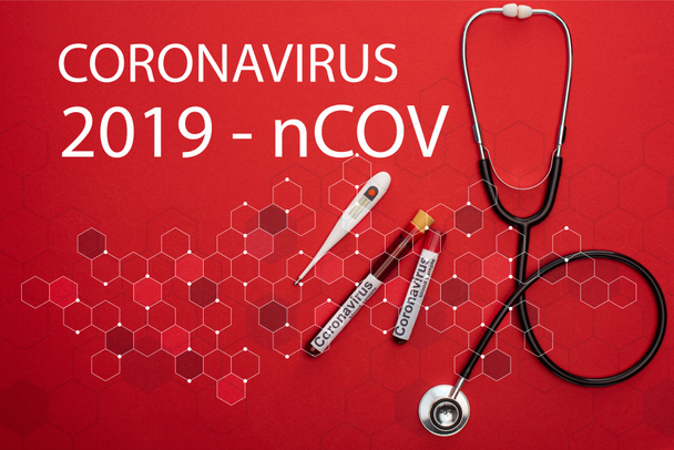 Stetoskop, termometre ve kan örnekleriyle test tüpleri ve kırmızı arkaplanda Coronavirus 2019-ncov harfleri. - Fotoğraf, Görsel