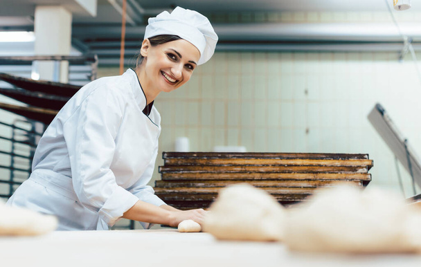 Baker with freshly baked bread in the bakery - Foto, afbeelding