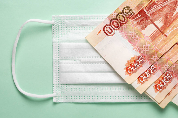 Medical mask with Russian money lying on it. - Foto, Imagen
