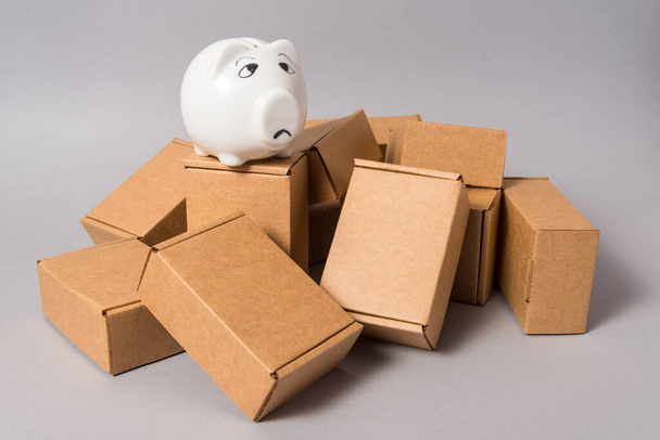 Big lot of brown cardboard mess boxes with empty piggy bank, no  - 写真・画像