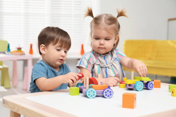 Little children playing with construction set at table - Foto, imagen