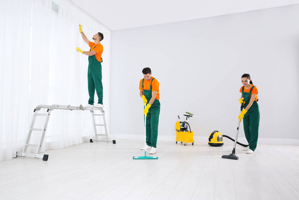 Team of professional janitors cleaning room after renovation - Fotografie, Obrázek