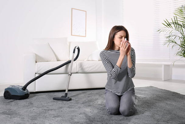 Young woman suffering from dust allergy while vacuuming house - Fotografie, Obrázek