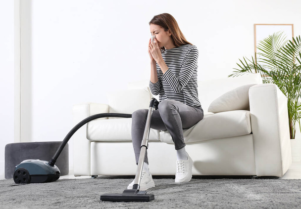 Young woman suffering from dust allergy while vacuuming house - Fotografie, Obrázek