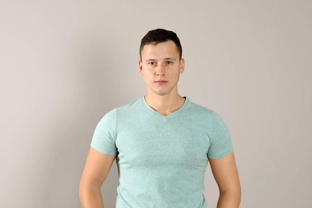 Confident handsome young man on beige background - Valokuva, kuva