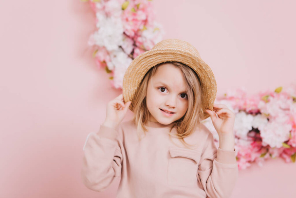 Image of sweet adorable girl with pink flowers in hat - Foto, imagen