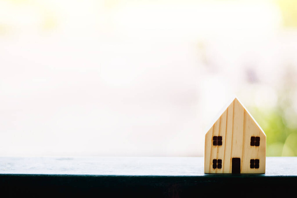Modelo de casa de madera contra fondo natural borroso al aire libre con espacio de copia para el concepto de vivienda
 - Foto, Imagen