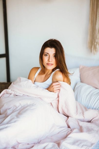 Young woman relax and smiling softly in bed. - Фото, изображение