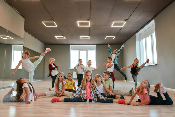 Keep dancing. Group of happy little boys and girls in fashionable clothes posing together in the dance studio. Dance team. - Foto, Bild