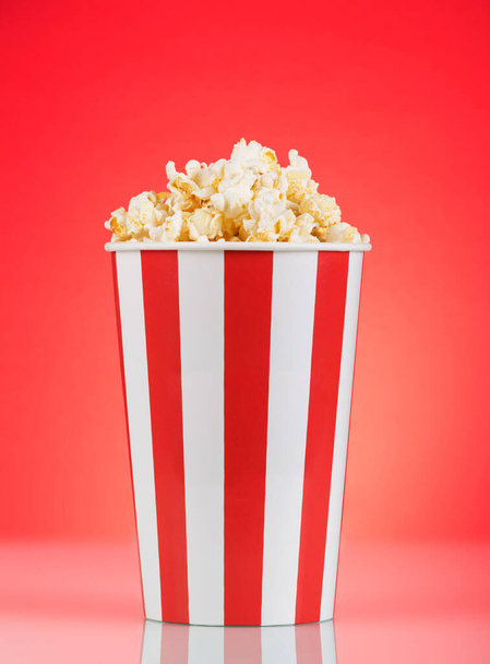 Large striped popcorn box on a bright red background - Foto, Imagen
