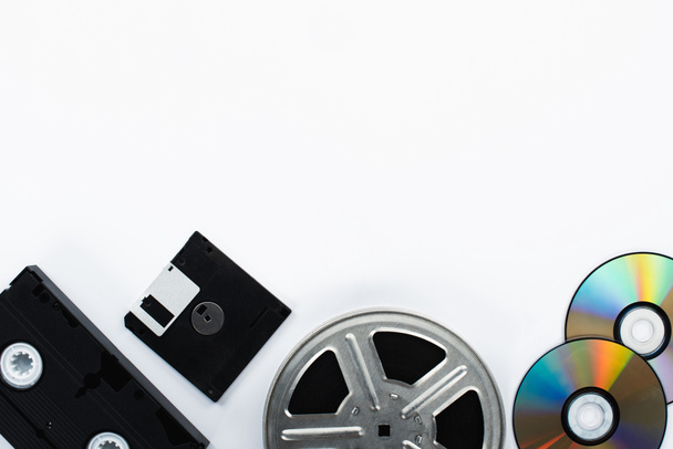 widok z góry kasety VHS, płyt CD, dyskietki i rolki filmowej na białym tle  - Zdjęcie, obraz
