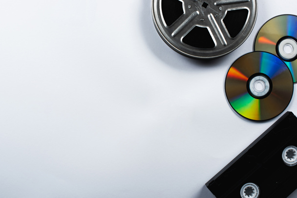 CDディスク、 VHSカセット、フィルムリールの白い背景のトップビュー - 写真・画像